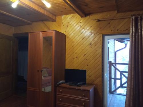 a room with a television on a dresser and a door at Sadyba Vyshenka in Tatariv