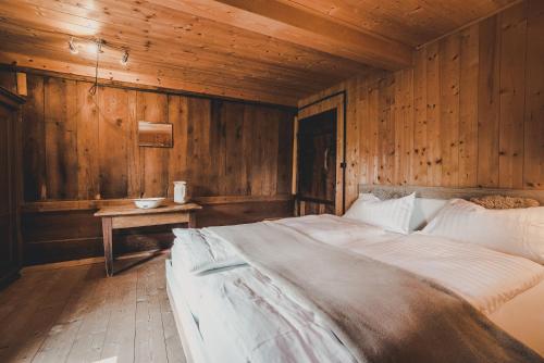 a bedroom with a large bed in a wooden wall at Knottn Hüttl, St. Pankraz/Ulten, Nähe Meran in San Pancrazio dʼUltimo