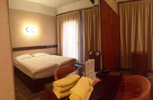 a hotel room with a bed and a person sitting at a desk at Parc Hotel Casa Mia in Lazise