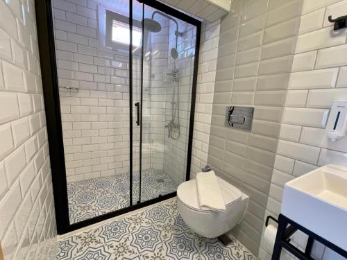 a bathroom with a toilet and a glass shower at YALI PANSİYON in Kas
