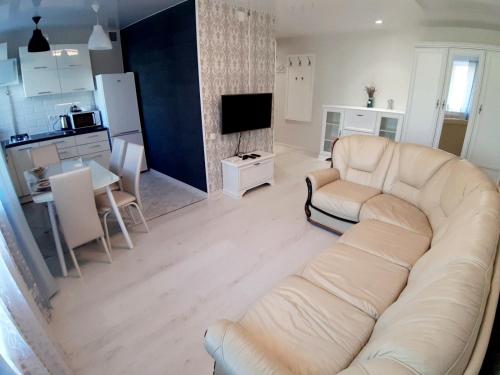 a living room with a white couch and a kitchen at Appartment NEW in Center in Mogilev