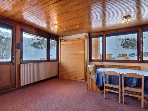 a bedroom with a bed in a room with windows at Studio La Plagne, 1 pièce, 4 personnes - FR-1-455-102 in La Plagne