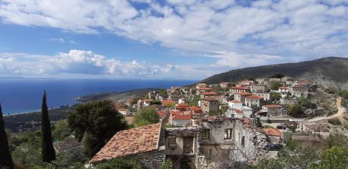 a village on a hill with the ocean in the background at Les Villas de Qeparo in Qeparo
