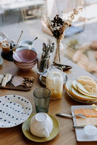 a wooden table with plates and dishes on it at Eco-lodge Villa Epicurea in Sesimbra