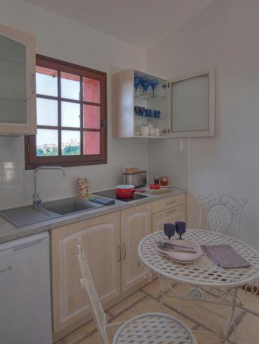 une cuisine avec une table et un évier et une table et des chaises dans l'établissement Une Maison à Saint-Paul de Vence, à Saint-Paul-de-Vence