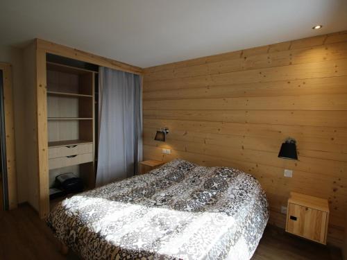 a bedroom with a bed in a wooden wall at Chalet Chamrousse, 5 pièces, 12 personnes - FR-1-340-211 in Chamrousse