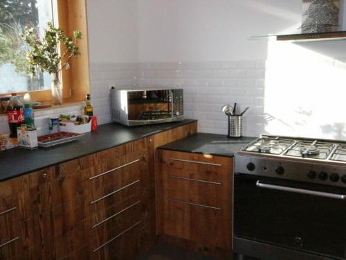 a kitchen with a stove and a microwave at Chalet Chamrousse, 5 pièces, 12 personnes - FR-1-340-211 in Chamrousse