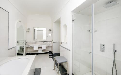 a white bathroom with a sink and a shower at Hotel Villa Franca in Positano