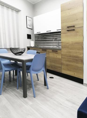 cocina con mesa, sillas y fregadero en Alex & Frank Apartment en Crotone