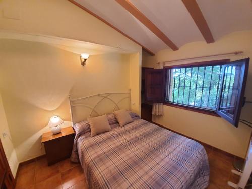 een slaapkamer met een bed en een raam bij Villa Rural Reconstruida in Riola