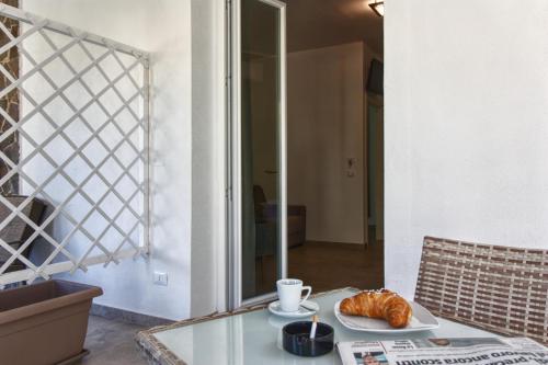 a glass table with a plate of croissants on it at B&B Le Muse in Mondello