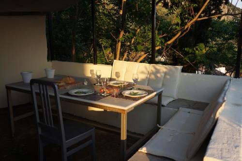 a table with plates and wine glasses on it at Les Villas de Qeparo in Qeparo