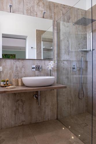 a bathroom with a sink and a glass shower at B&B Le Muse in Mondello