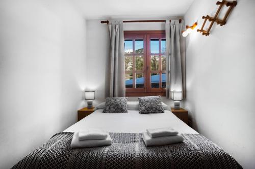 sypialnia z łóżkiem z 2 poduszkami i oknem w obiekcie Francoli w mieście Canillo