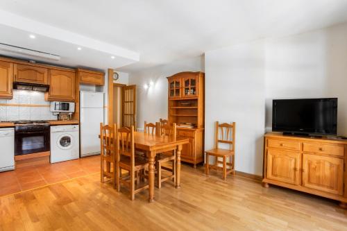a kitchen with a table and chairs and a television at Refugis Francoli Canillo in Canillo
