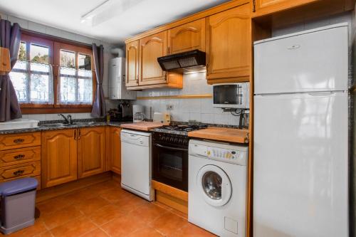 a kitchen with wooden cabinets and a white refrigerator at Refugis Francoli Canillo in Canillo