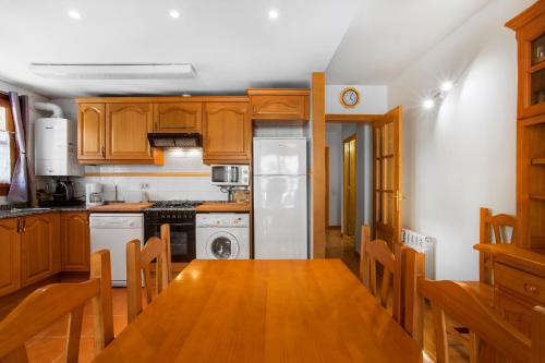 a kitchen with wooden cabinets and a dining room table at Refugis Francoli Canillo in Canillo