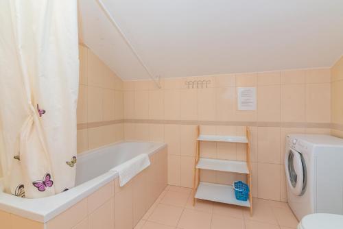 a bathroom with a tub and a washing machine at Apartment Mimoza 6, Baska, Krk in Baška