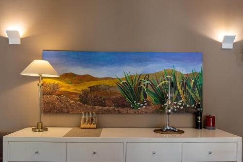 a painting hanging on a wall above a dresser at B&B Le Muse in Mondello