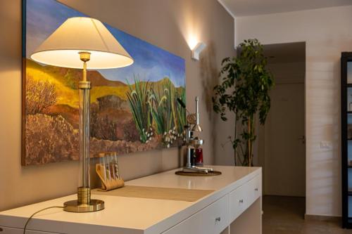 a lamp on a kitchen counter with a painting on the wall at B&B Le Muse in Mondello