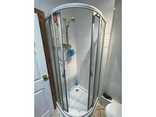 eine Dusche mit einer Glastür in einem Badezimmer in der Unterkunft Hollybank Cottage in Lochgoilhead
