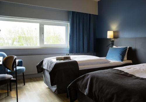 a hotel room with two beds and a window at Scandic Odense in Odense
