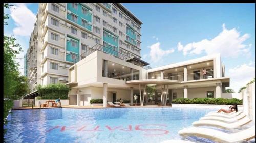 ein Hotel mit einem Pool vor einem Gebäude in der Unterkunft One Spatial Two Bedroom Condominium Unit with Pool and Gym free Netflix and wifi in Iloilo City