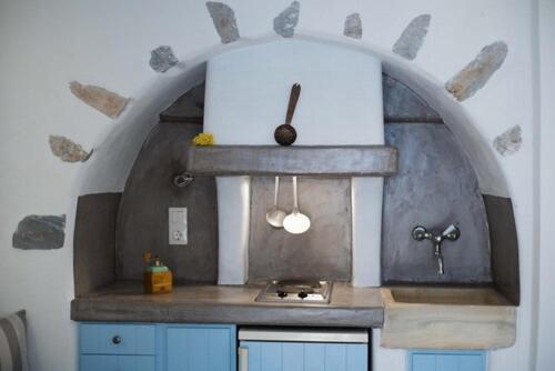 una cocina con fregadero y un arco sobre él en The Big Blue, en Órmos Aiyialís