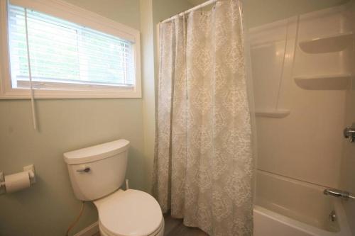 a bathroom with a toilet and a shower with a window at Outdoor Playground on Lake and Close to Skiing in Windsor