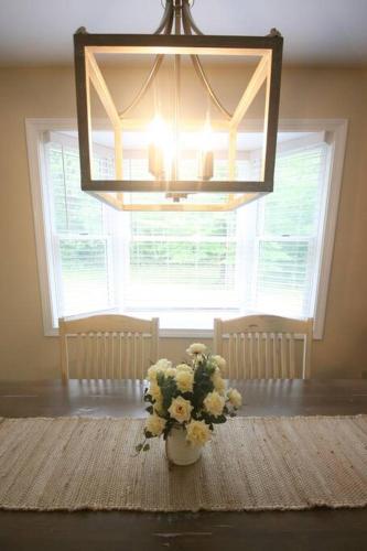 a vase of flowers on a table in front of a window at Outdoor Playground on Lake and Close to Skiing in Windsor