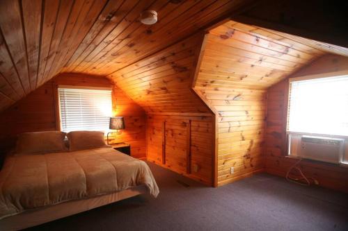 a bedroom with a bed in a wooden cabin at Outdoor Playground on Lake and Close to Skiing in Windsor