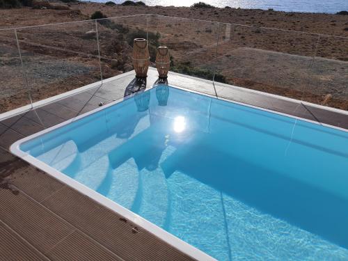a swimming pool with two vases on top of it at Tramonto Luxury Villa No1- Breathtaking sunset view in Karpathos Town