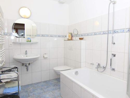 a bathroom with a tub and a toilet and a sink at Sportpension Färbinger in Berchtesgaden