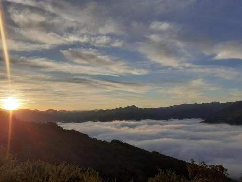 a view of the sun rising over the clouds in the mountains at Pedroenea Apartamento Elizondo in Elizondo