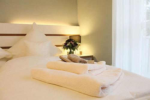 a white bed with towels on top of it at Inklusions- und Panorama Hotel Kochsberg in Grebendorf