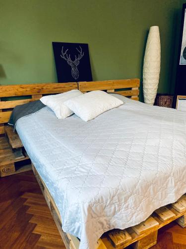 a wooden bed with white sheets in a room at Großes Ferienzimmer Uckermark in Casekow