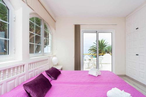 タコロンテにあるAcogedora Vivienda en Tenerife con vistasy piscinaの白い部屋の紫色のベッド1台