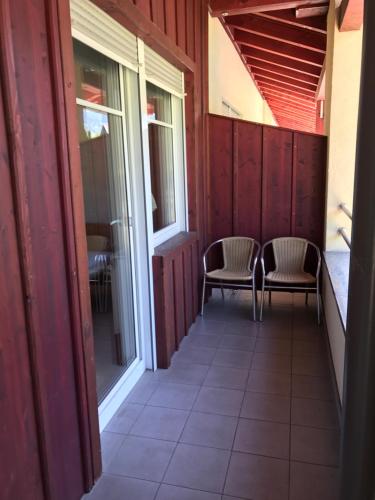 a balcony of a house with two chairs and windows at Apartment Mölltaler Gletscher 6 in Ausserfragant