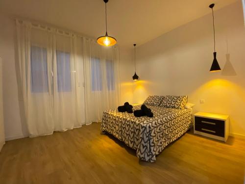 - une chambre avec un lit avec deux chats assis dans l'établissement Casa adosada a 20 min centro de Barcelona, à L'Hospitalet de Llobregat