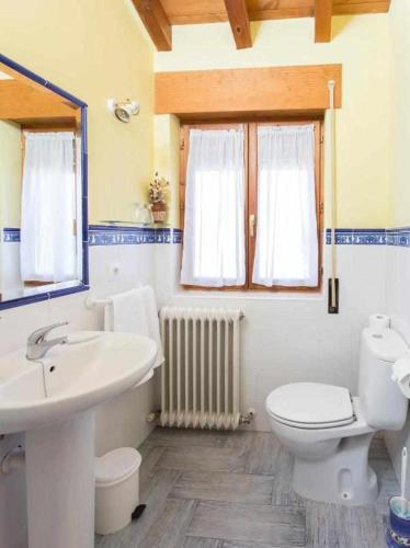 a bathroom with a toilet and a sink at Casa Rural El Hidalgo en Amaya Burgos in Amaya