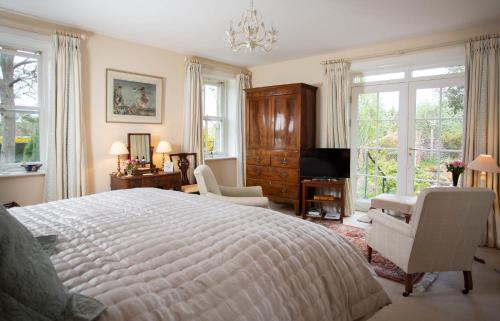 a bedroom with a large bed and a living room at Ingram House Bed & Breakfast in Alnwick