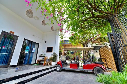 a red car parked in front of a house at Coto Center Homestay in Dao Co To
