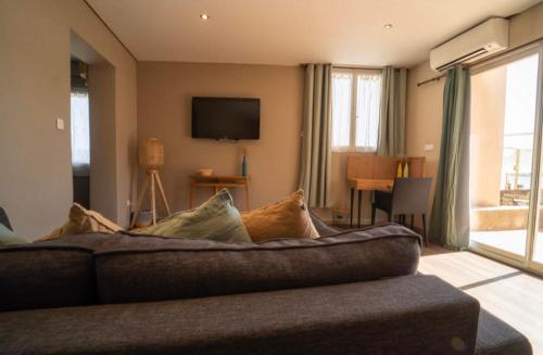 a living room with a couch and a television at Palm Beach in Ajaccio