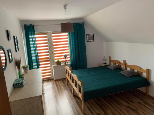 - une chambre avec un lit vert et une fenêtre dans l'établissement Dom pod Skrzycznem, à Lipowa