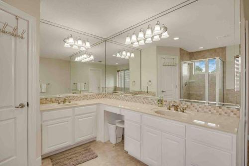a bathroom with two sinks and a large mirror at Canyon Lake Home with Breathtaking View in Canyon Lake
