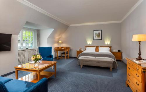 a hotel room with a bed and a couch at Landhaus Carstens in Timmendorfer Strand