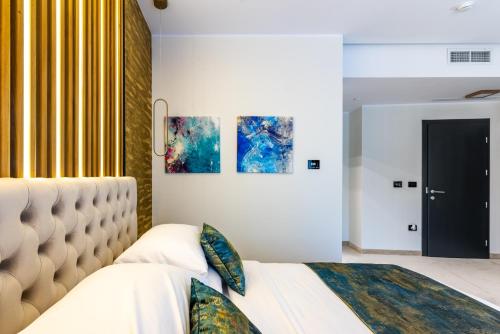 a bedroom with a white bed with a large headboard at Hotel Ivascu in Moisei