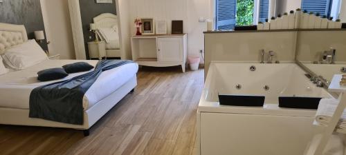 - une chambre avec un lit blanc et une baignoire dans l'établissement B&B Emozioni e Relax, à Pietole