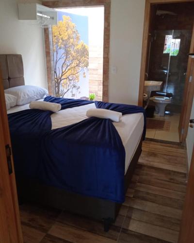 a bedroom with a large bed with blue sheets at Pousada Lótus in Chapada dos Guimarães