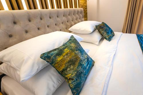 a bed with three pillows on top of it at Hotel Ivascu in Moisei